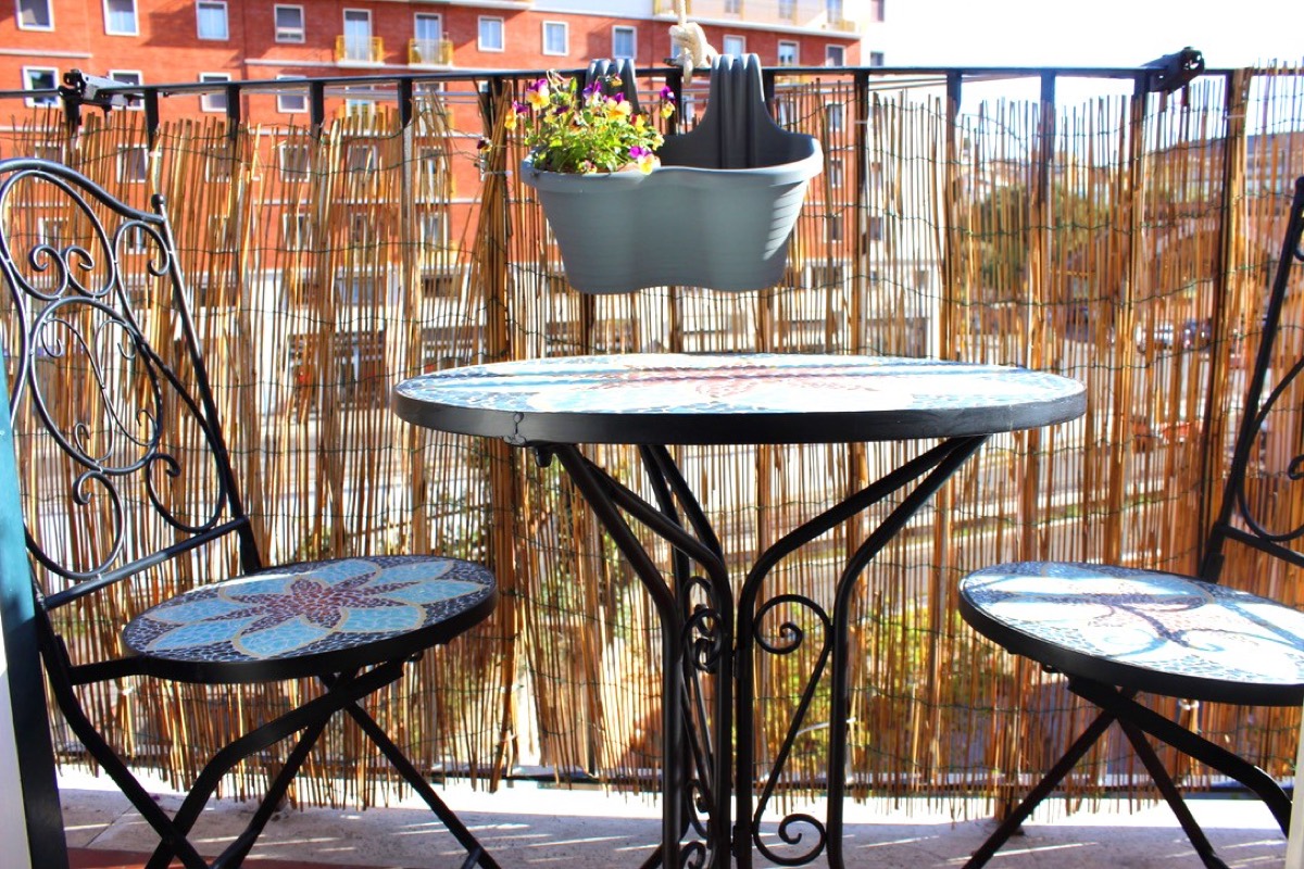 Balcony with a mosaic bistro table and two chairs