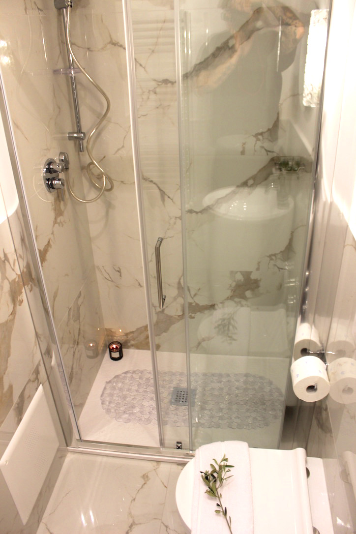 Glass shower with marble-effect tiles