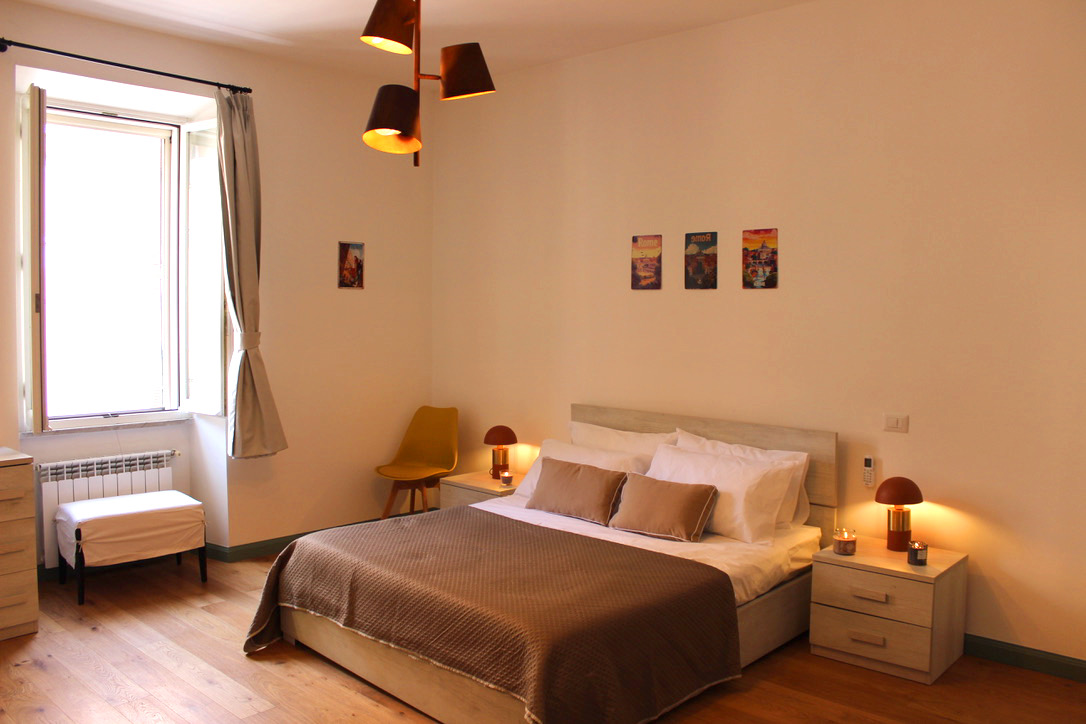 Ensuite 1: double bed with bedside lamps and a tall window