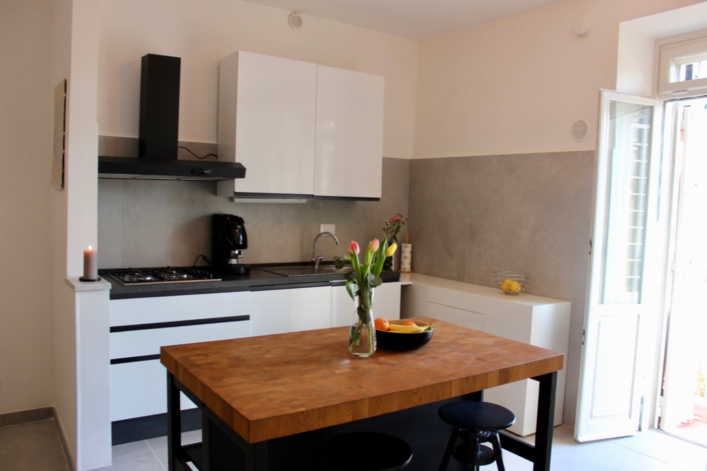 Kitchen island with butcher-block top, stools and a gas hob